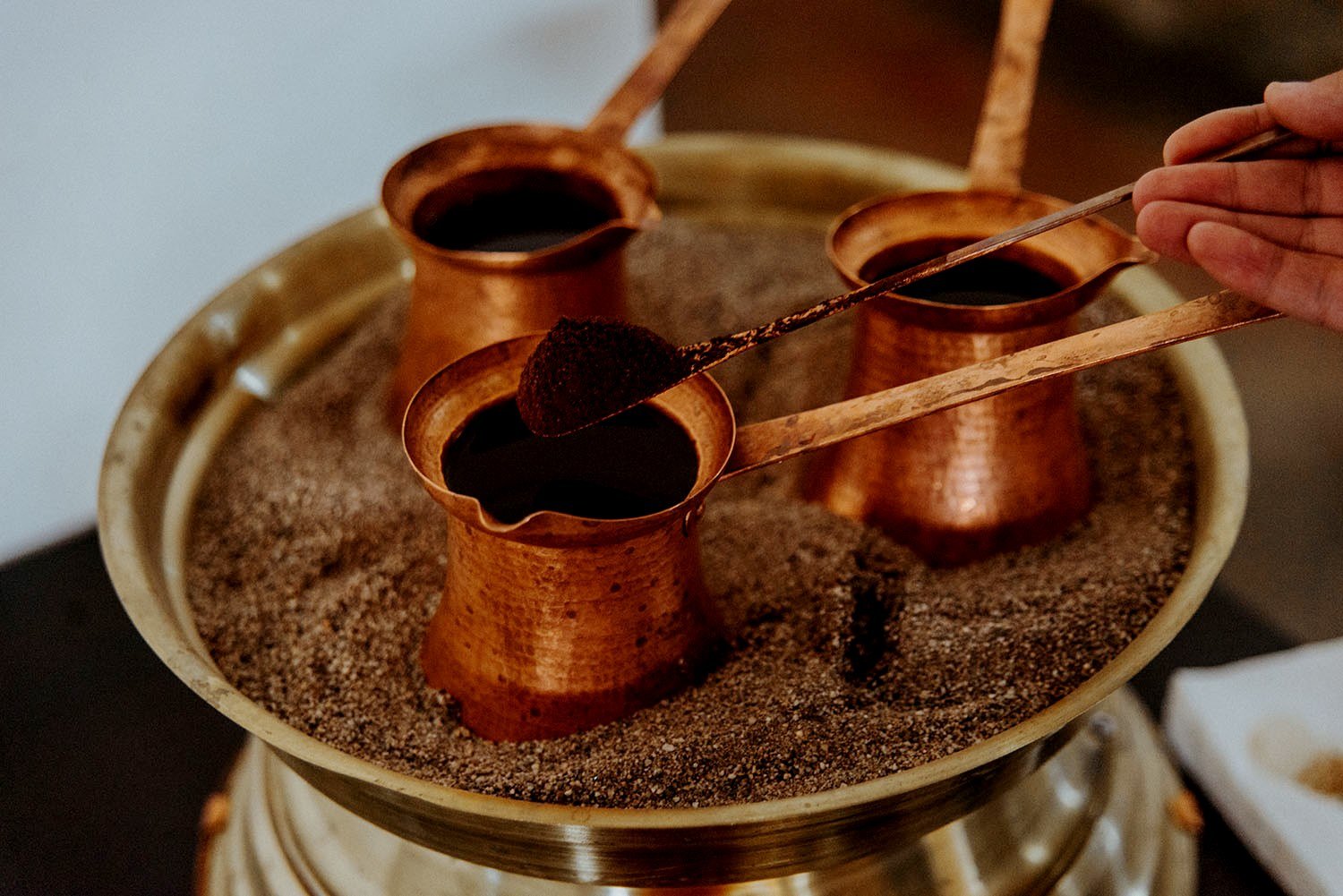 В турции подают кофе с водой. Турецкая джезва для кофе. Кофе на песке. Кофе в турке. Кофе в турке на песке.