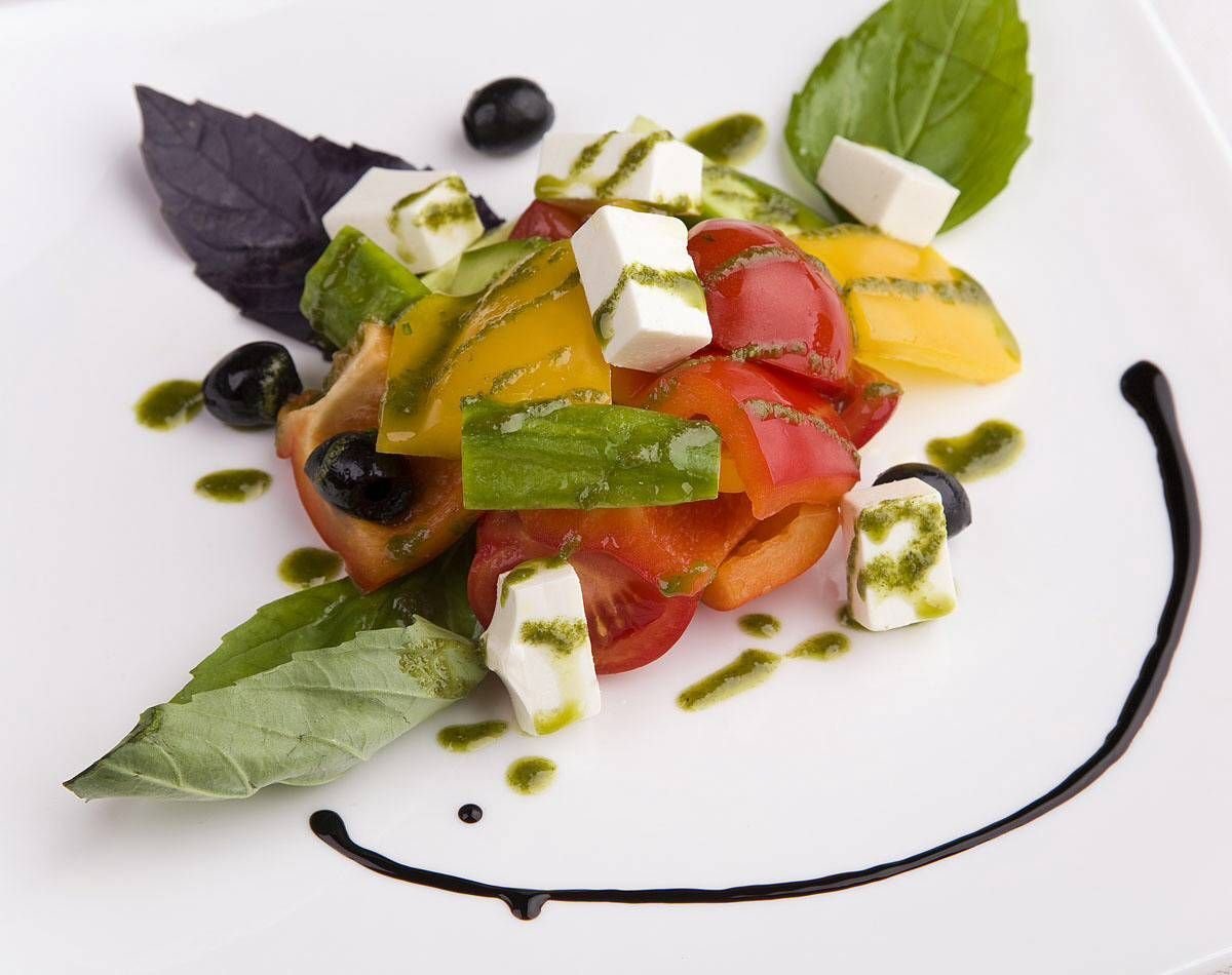 Блюда из овощей соусом. Греческий салат с соусом песто. Греческий салат с оливками Каламата. Ресторанная подача салатов. Греческий салат фото.